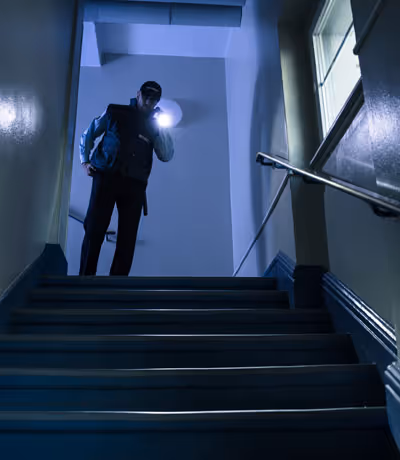 image of the security guard with a flashlight patrolling the place